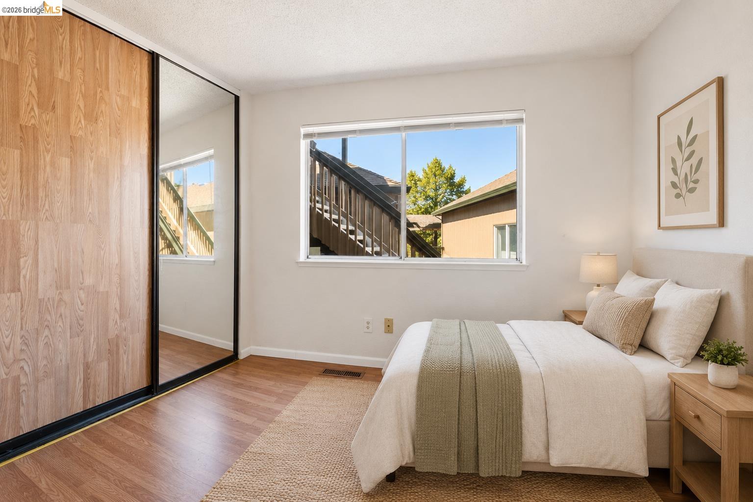 1151 Chadwick Circle Bay Point, CA 94565 - Photo 11 of 23 Room featuring wood-finish flooring, a window with exterior views, and a full-wall closet with wood-finish and mirrored sliding doors