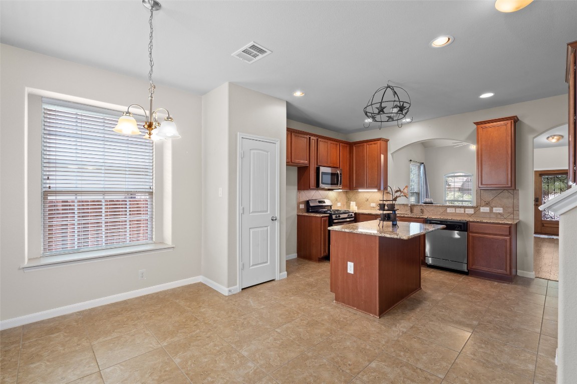 8540 White Ibis Drive Austin, TX 78729 - Photo 11 of 39 a room with kitchen island and a window