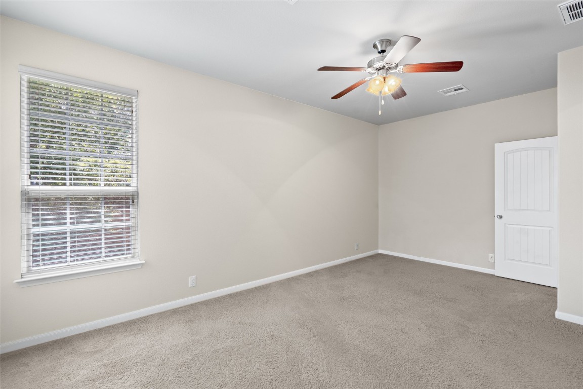 8540 White Ibis Drive Austin, TX 78729 - Photo 13 of 39 an empty room with windows and fan