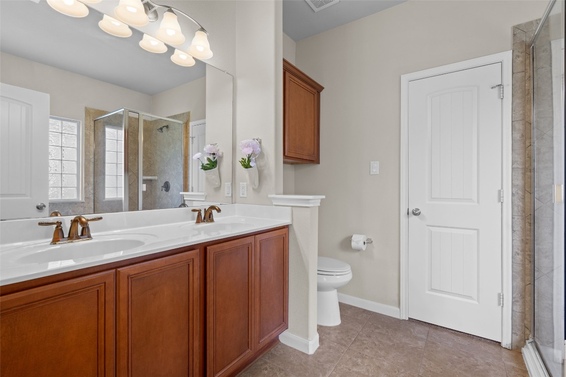 8540 White Ibis Drive Austin, TX 78729 - Photo 14 of 39 a bathroom with a double vanity sink and a mirror