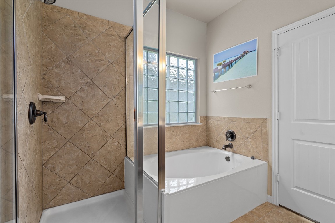 8540 White Ibis Drive Austin, TX 78729 - Photo 16 of 39 a bathroom with a bathtub and shower