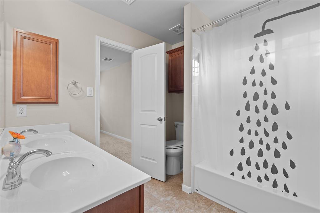 8540 White Ibis Drive Austin, TX 78729 - Photo 24 of 39 a bathroom with a sink a toilet and shower