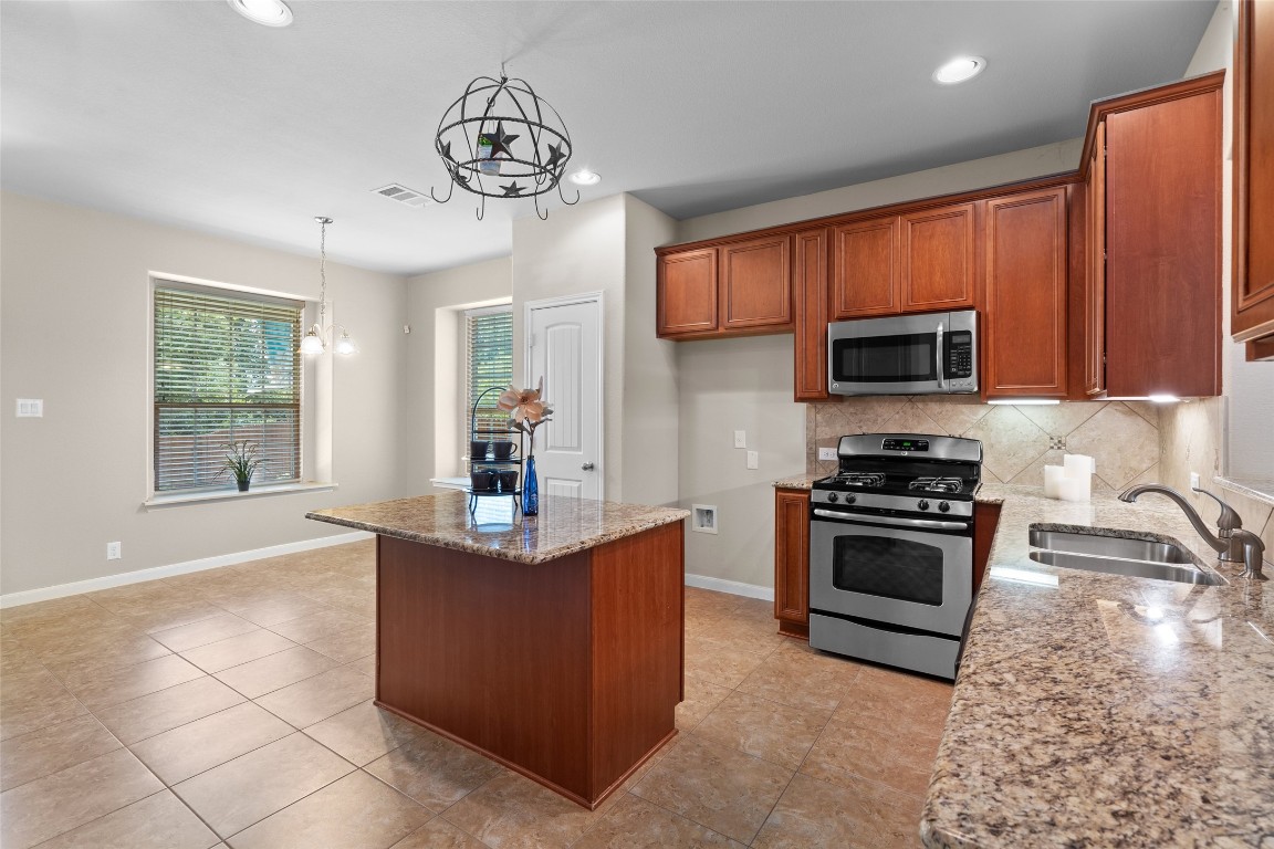 8540 White Ibis Drive Austin, TX 78729 - Photo 6 of 39 a kitchen with stainless steel appliances granite countertop a stove a sink and a microwave