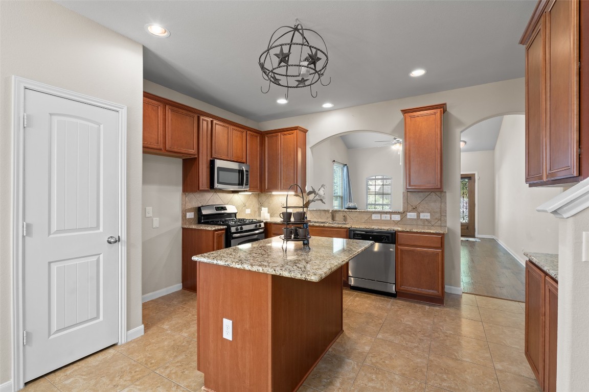 8540 White Ibis Drive Austin, TX 78729 - Photo 7 of 39 a kitchen with stainless steel appliances granite countertop a sink stove and refrigerator