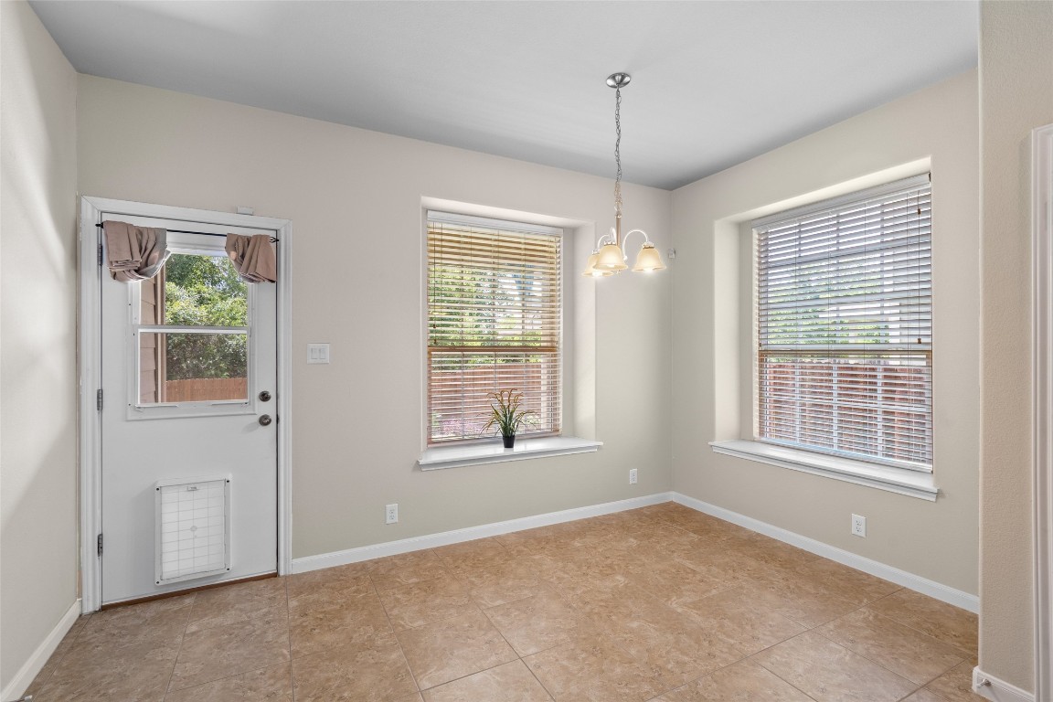 8540 White Ibis Drive Austin, TX 78729 - Photo 9 of 39 a view of an empty room with windows and chandelier