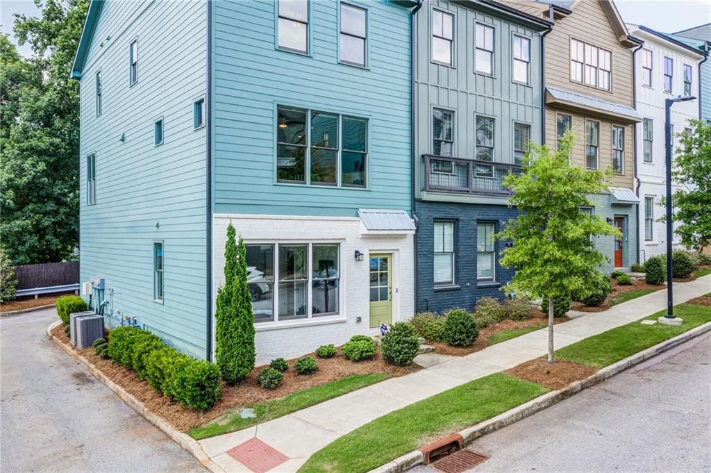 a front view of a house with a yard and potted plants
