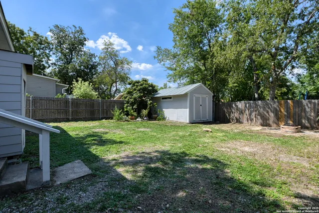 a front view of a house with a yard and tree
