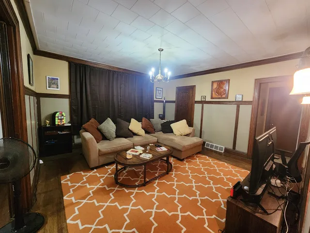 a living room with furniture a lamp and a rug