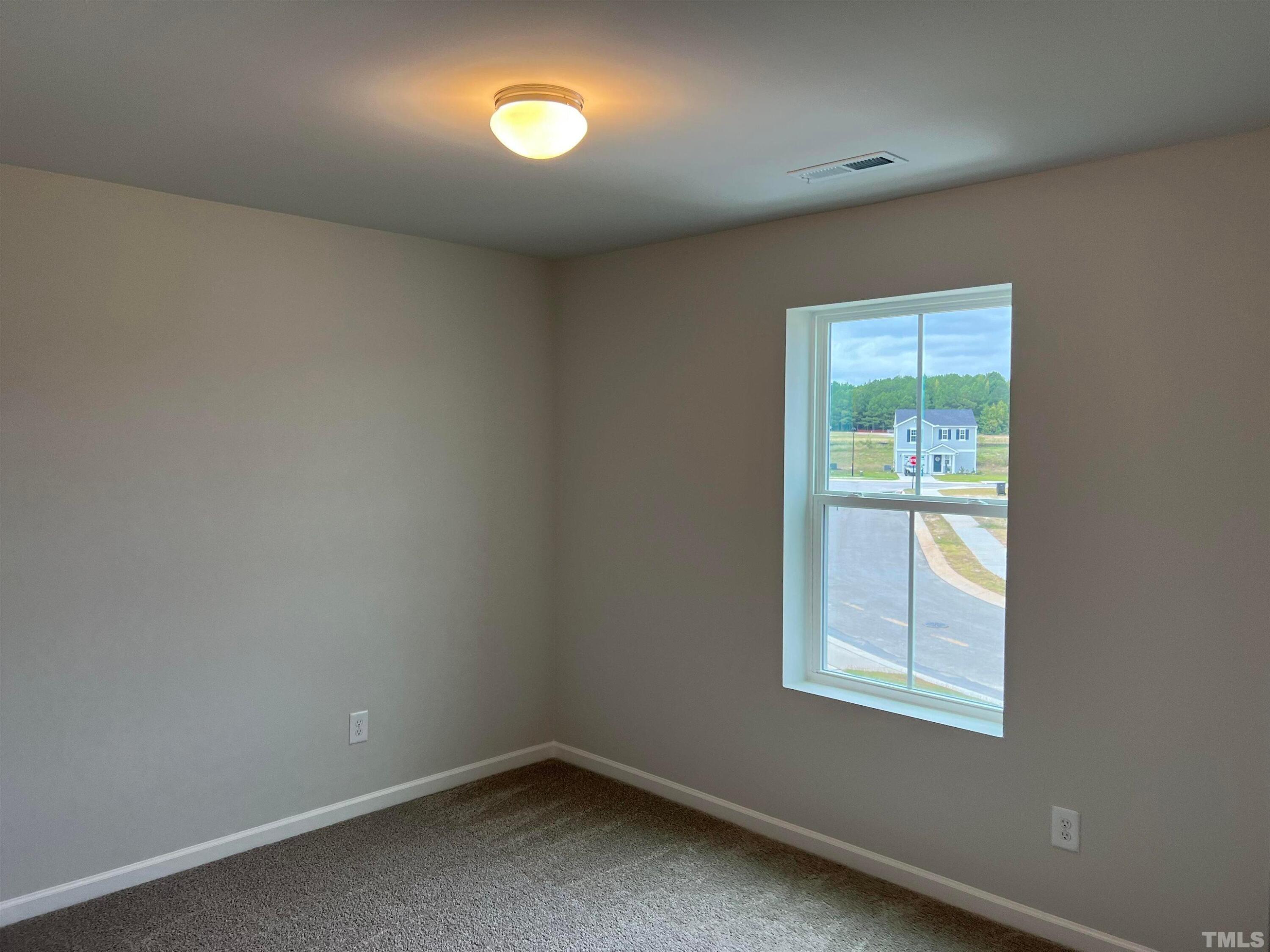 179 Maple Tree Lane Clayton, NC 27527 - Photo 17 of 18 an empty room with a window
