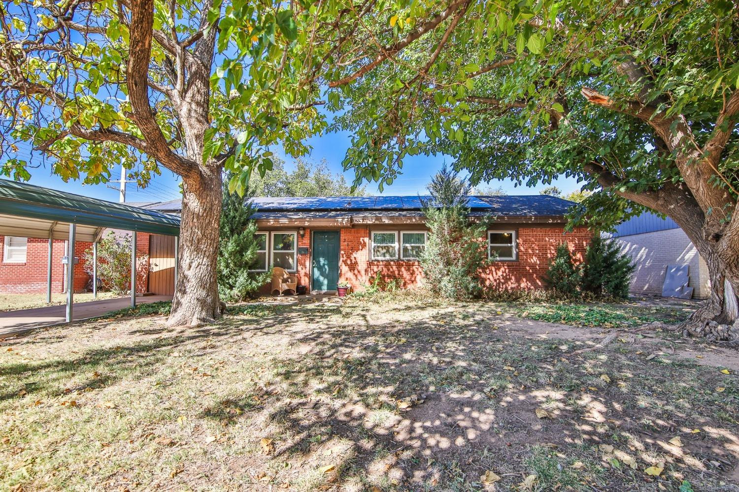 2824 63rd Street Lubbock, TX 79413 - Photo 1 of 24 a front view of a house with a garden
