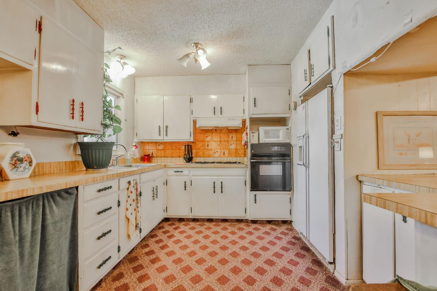 2824 63rd Street Lubbock, TX 79413 - Photo 7 of 24 a kitchen with granite countertop white cabinets and white appliances