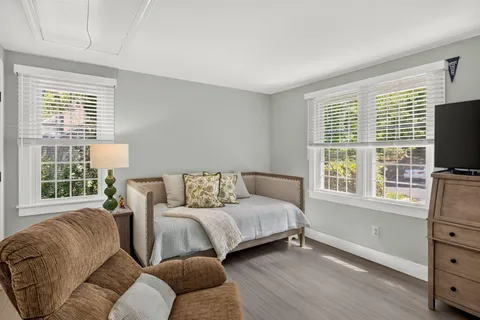 a living room with furniture a flat screen tv and a window