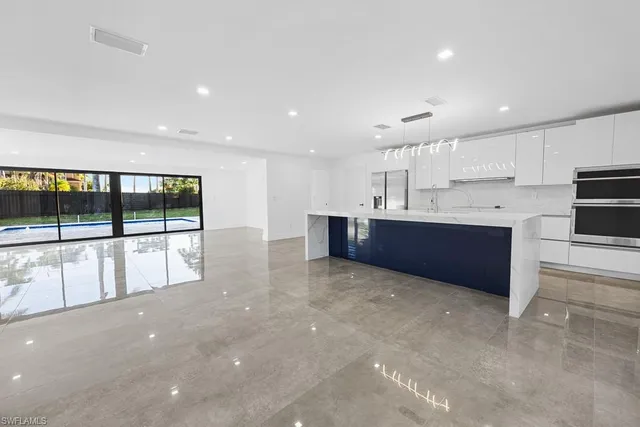 a view of kitchen with a sink wooden cabinets and window