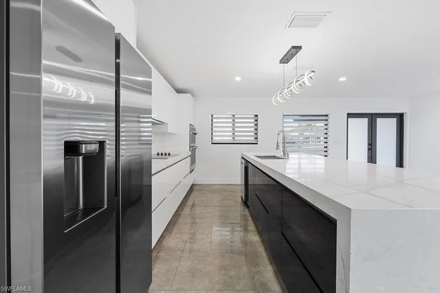 a kitchen with a sink a counter top space and stainless steel appliances