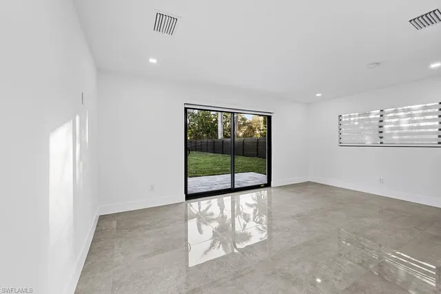 an empty room with mirror on vanity