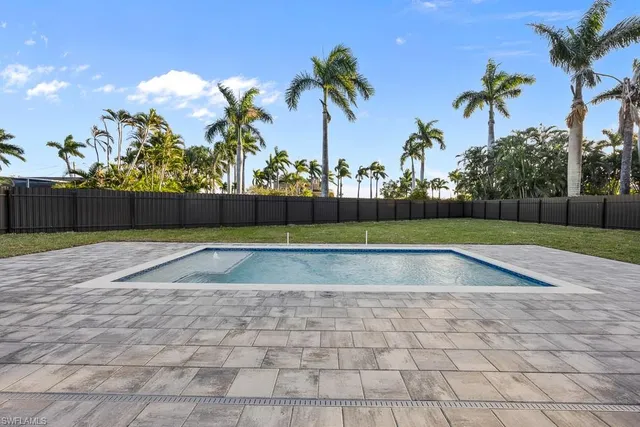 a view of a house with a yard and potted plants
