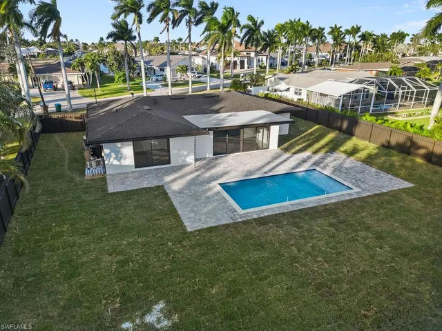 an aerial view of residential houses with outdoor space and swimming pool