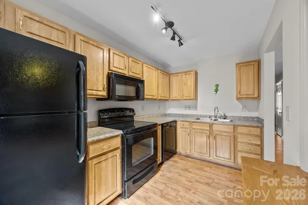 a kitchen with stainless steel appliances granite countertop a refrigerator a stove a sink and a microwave