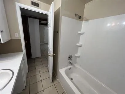 a bathroom with a tub a sink and a shower