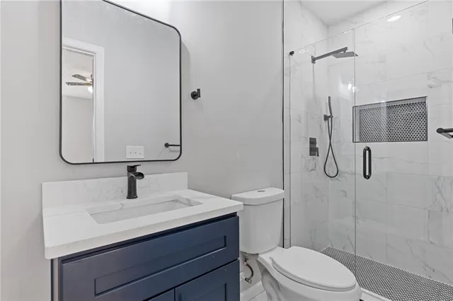 a bathroom with a sink toilet vanity and shower