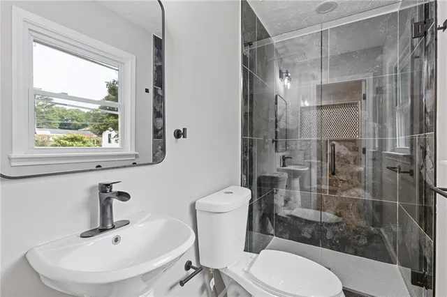 a bathroom with a sink toilet and shower