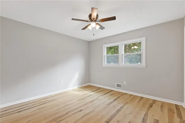 a view of a room with wooden floor and fan