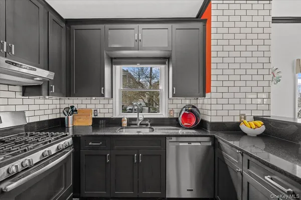a kitchen with stainless steel appliances a stove window and cabinets