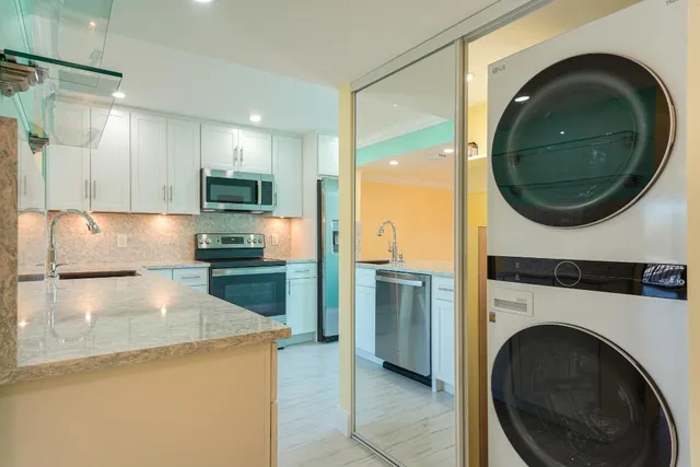 a kitchen with kitchen island a stove a washer and dryer