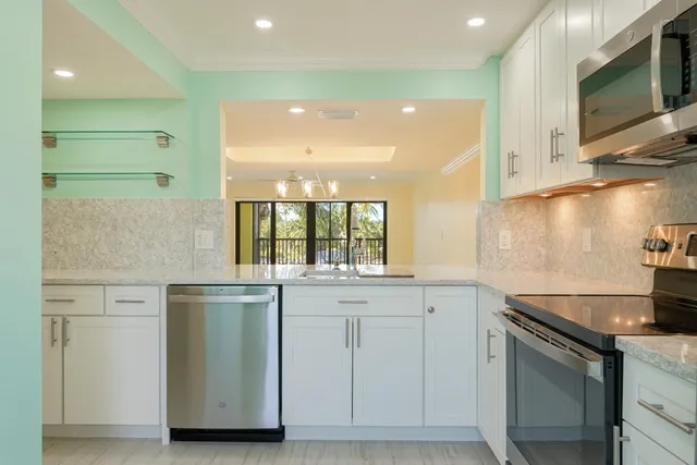 a kitchen with granite countertop white cabinets and a sink