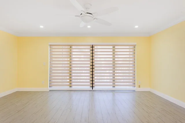 a view of a big room with wooden floor and windows