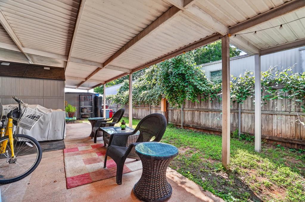6602 Ashley Court Granbury, TX 76049 - Photo 24 of 35 Expansive covered patio featuring a metal roof structure, concrete flooring, and string lighting