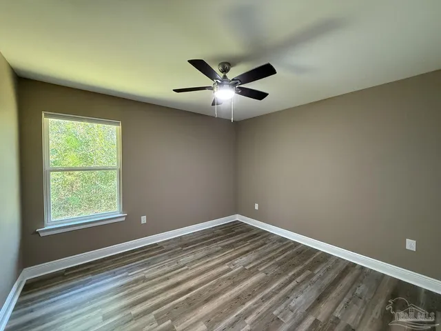 an empty room with a window and a fan