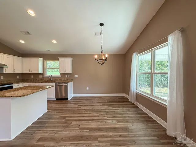 a large kitchen with granite countertop a stove and a sink