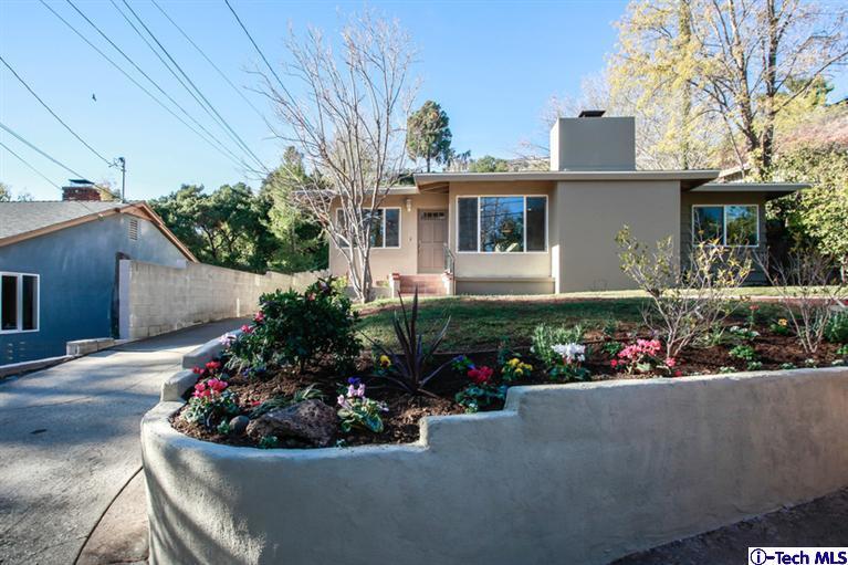 a house with lots of flowers in front of it