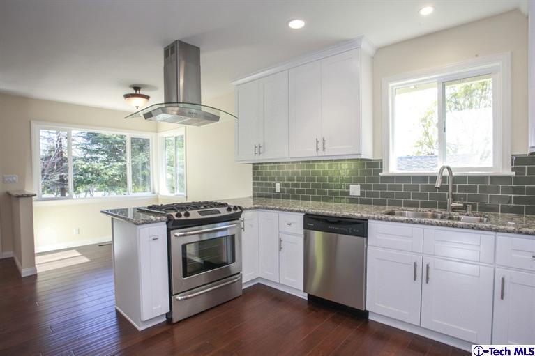 4465 Rising Hill Road Altadena, CA 91001 - Photo 16 of 45 a kitchen with stainless steel appliances granite countertop a stove and white cabinets