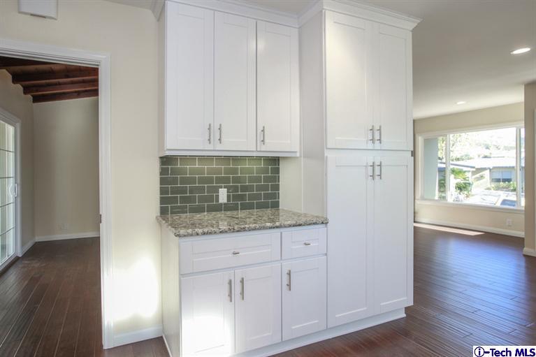 4465 Rising Hill Road Altadena, CA 91001 - Photo 19 of 45 a kitchen with granite countertop white cabinets and a wooden floor