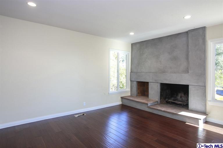 4465 Rising Hill Road Altadena, CA 91001 - Photo 5 of 45 an empty room with wooden floor fireplace and windows