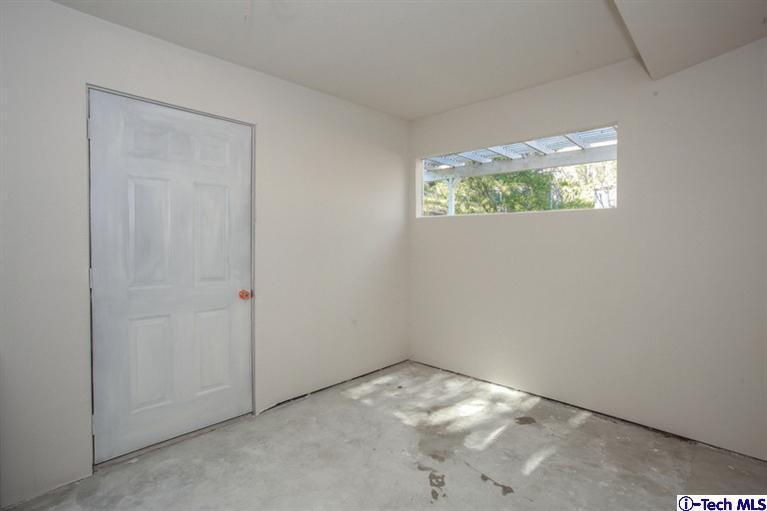 4465 Rising Hill Road Altadena, CA 91001 - Photo 43 of 45 an empty room with wooden floor and windows