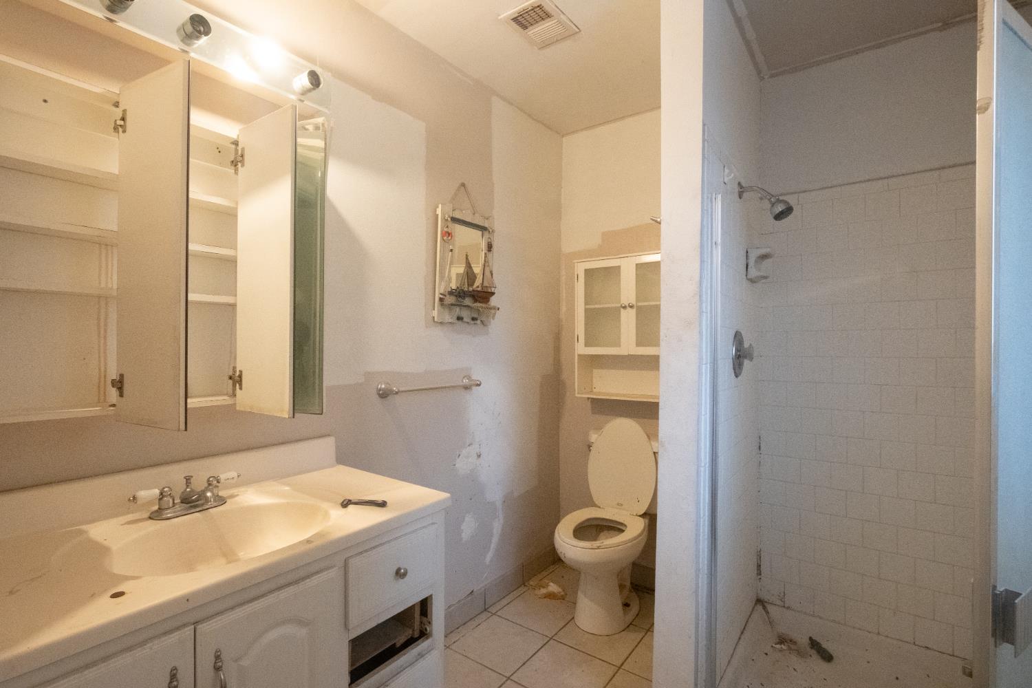 6401 South Chestnut Avenue Fresno, CA 93725 - Photo 13 of 36 a bathroom with a granite countertop sink toilet and shower