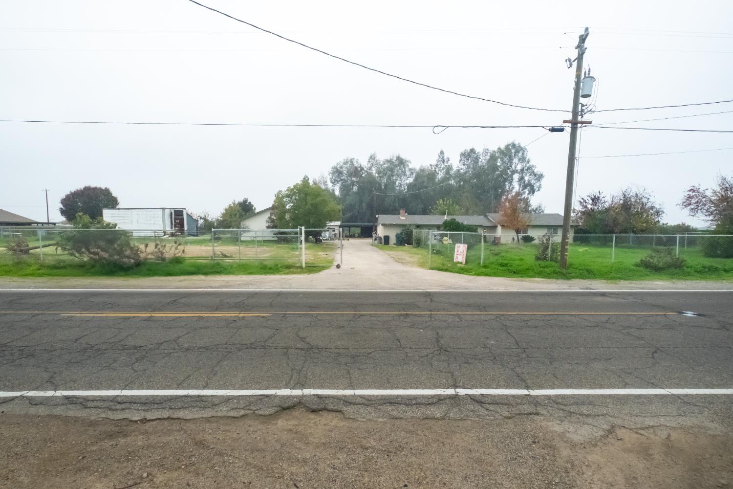6401 South Chestnut Avenue Fresno, CA 93725 - Photo 2 of 36 a view of a yard and a car parked on the road