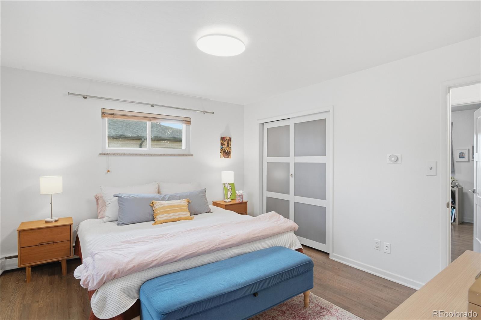 5974 South Pennsylvania Street Centennial, CO 80121 - Photo 12 of 46 a bedroom with a bed and wooden floor