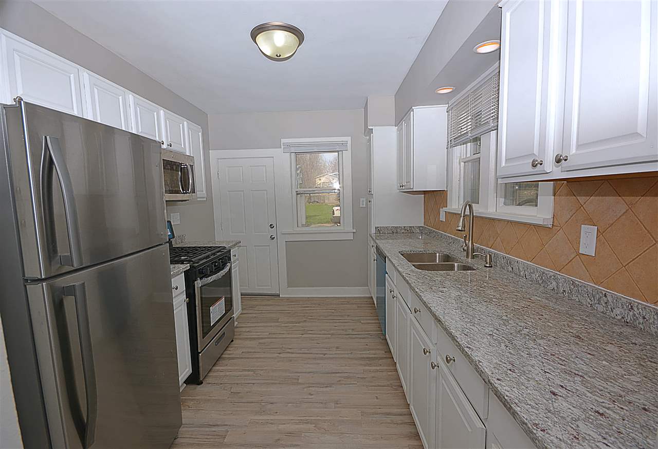 523 10th Avenue Rochelle, IL 61068 - Photo 12 of 22 a kitchen with granite countertop a refrigerator a sink and white cabinets