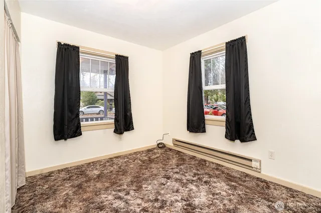 a view of a hallway with wooden floor and windows
