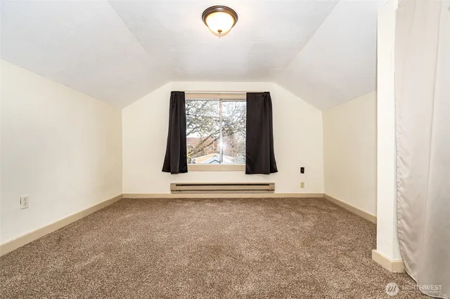 a view of a hallway with wooden floor and windows