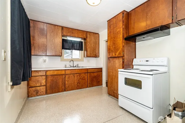 a kitchen with sink a stove and cabinets