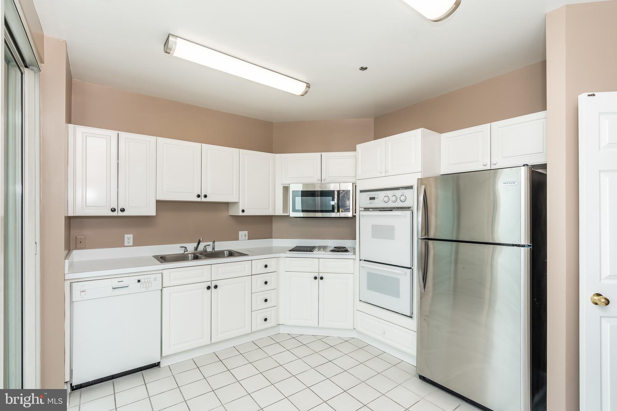 100 Harborview Drive, Unit 1908 Baltimore, MD 21230 - Photo 16 of 60 a kitchen with white cabinets and white appliances