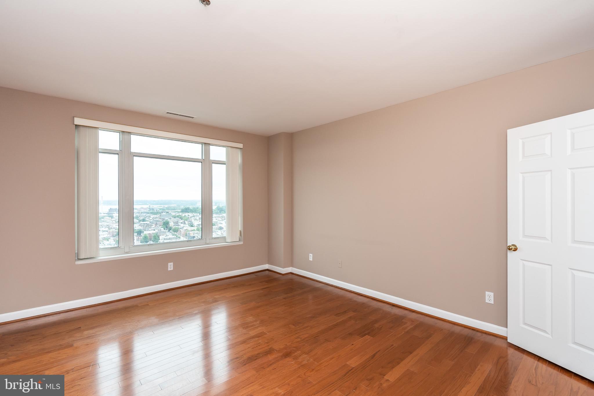 100 Harborview Drive, Unit 1908 Baltimore, MD 21230 - Photo 21 of 60 an empty room with wooden floor and windows