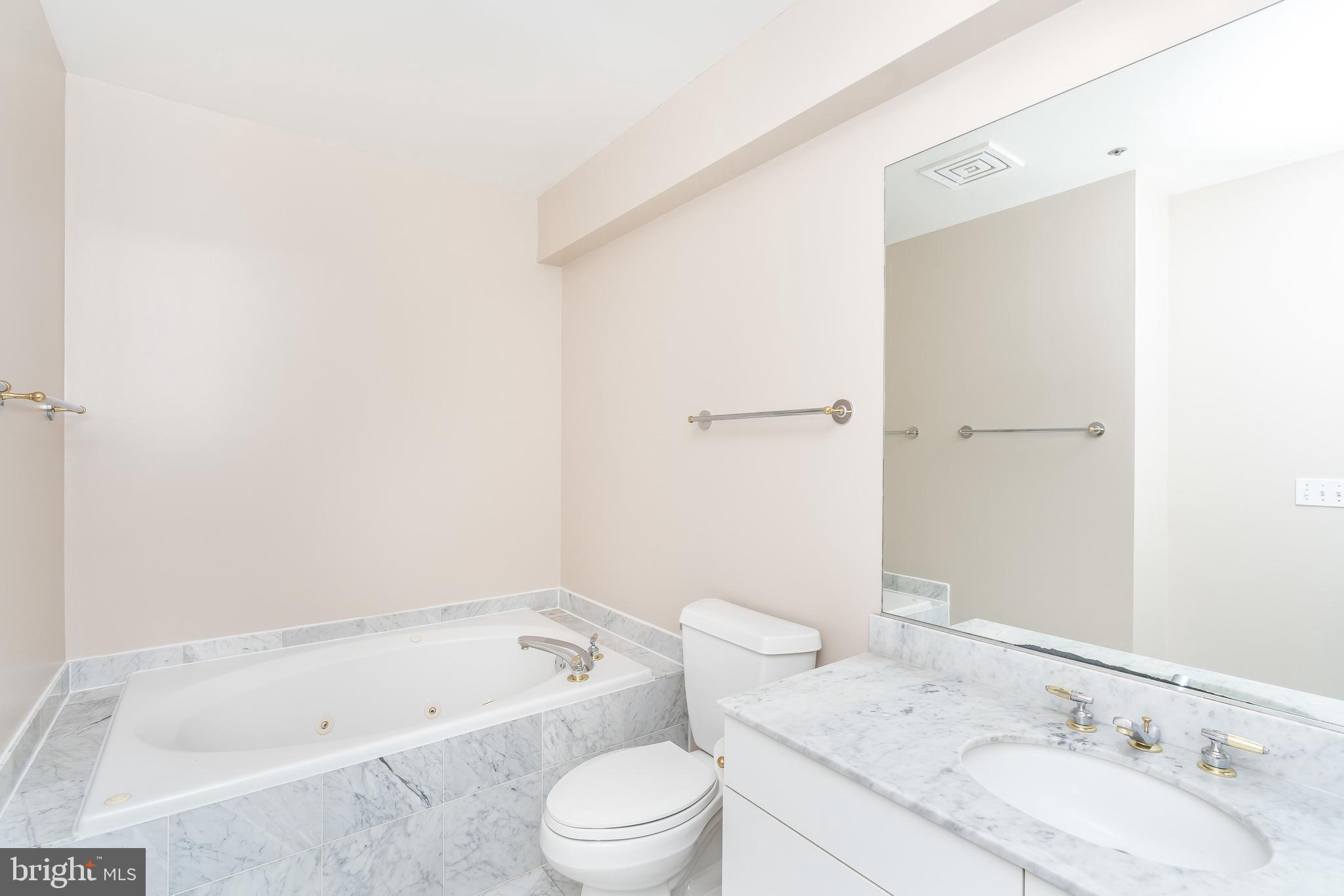100 Harborview Drive, Unit 1908 Baltimore, MD 21230 - Photo 27 of 60 a bathroom with a granite countertop sink a toilet and bathtub