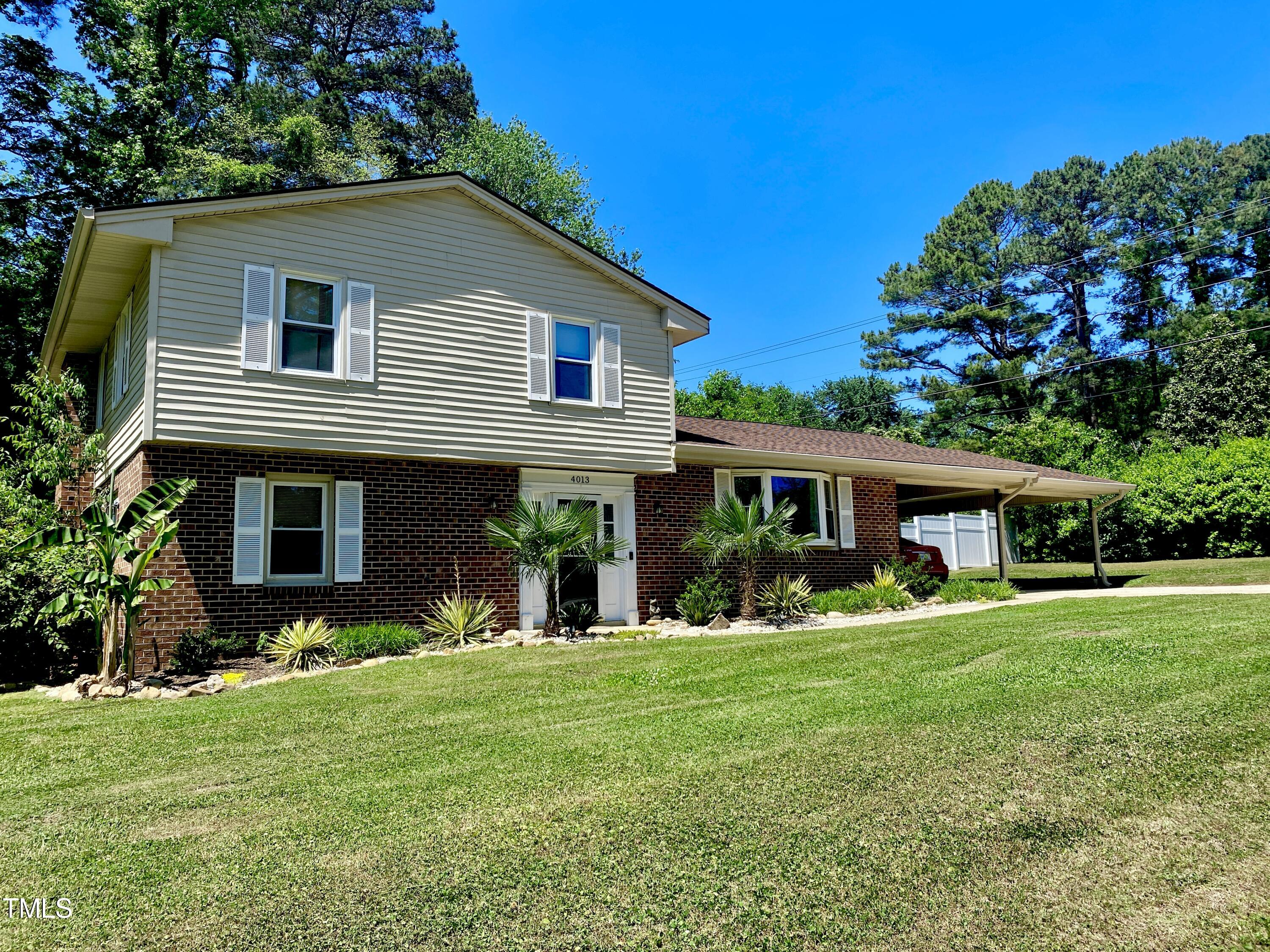 a front view of house with a garden and trees