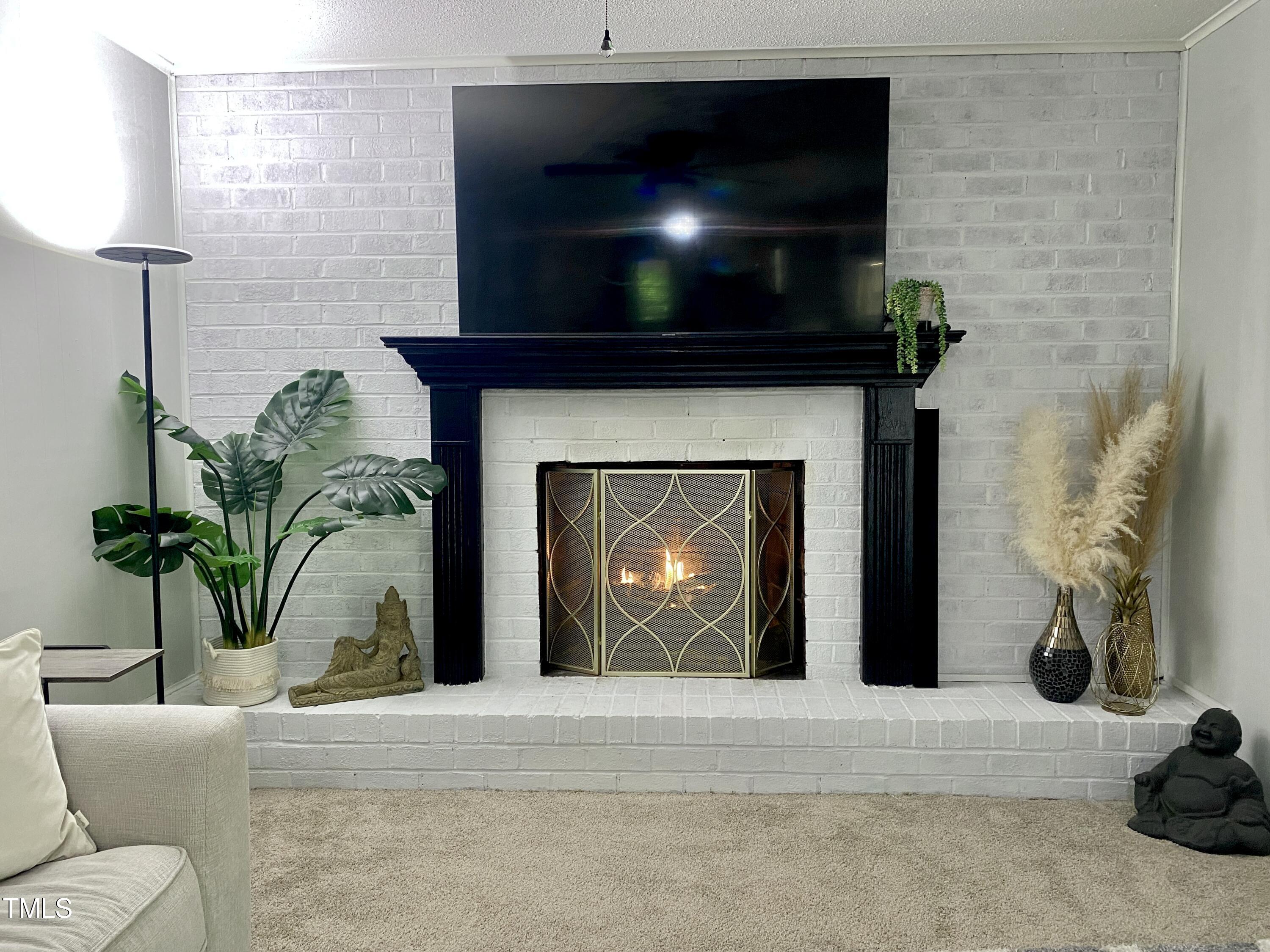 4013 Ingram Drive Raleigh, NC 27604 - Photo 11 of 29 a living room with a fireplace furniture a potted plant and a fireplace